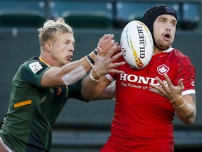 Canada's Jake Thiel, right, battles for the ball against South Africa's J.C. Pretorius during HSBC Canada Sevens rugby action in Edmonton, Saturday, Sept. 25, 2021.