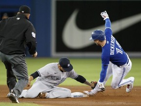 New York Yankee Gleyber Torres #25 of the New York Yankees misses the tag on the Jays' Corey Dickerson at Rogers Centre on Thursday. Getty Images