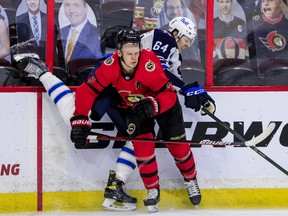 Senators forward Brady Tkachuk (front) checks Winnipeg Jets defenceman Logan Stanley last season. With training camp set to open next Wednesday, the Senators are still working on getting a deal done with Tkachuk.