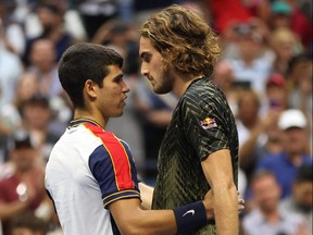 Carlos Alcaraz, left, of Spain meets at the net after defeating Stefanos Tsitsipas of Greece during his Men's Singles third round match on Day 5 at USTA Billie Jean King National Tennis Center on Sept. 3, 2021 in New York City.