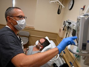 Nurse Chris Prott examines a patient in the urgent care department at the Iron Mountain VA Medical Center in Iron Mountain, Mich., Aug. 25, 2021.