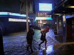 Spectators walk through flooded paths near Louis Armstrong Stadium on day three of the U.S. Open at USTA Billie Jean King National Tennis Center in Flushing, N.Y., Wednesday, Sept. 1, 2021.