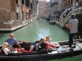Tourists ride on a gondola as the municipality prepares to charge them up to 10 euros for entry into the lagoon city, in order to cut down the number of visitors, in Venice, Italy, Sept. 5, 2021.