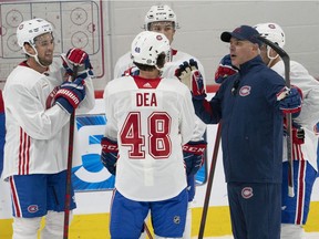 Montreal Canadiens head coach Dominique Ducharme speaks to Chris Wideman, left Joshua Roy and Jean-Sébastien Dea during training camp on Sept. 23, 2021, in Brossard.