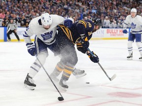 Toronto Maple Leafs defenceman Jake Muzzin checks Buffalo Sabres centre Zemgus Girgensons as he skates with the puck at KeyBank Center Feb. 16, 2020.