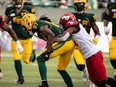 Edmonton Elks' Derel Walker (87) is tackled by Calgary Stampeders' Richard Leonard (4) during first half CFL football action at Commonwealth Stadium in Edmonton, on Saturday, Sept. 11, 2021. Photo by Ian Kucerak