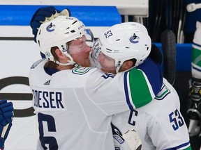 Brock Boeser and Bo Horvat embrace after the Canucks' 5-2 win over the St. Louis Blues in Game 1 of their NHL Western Conference playoff series at Rogers Place in Edmonton on Aug. 12, 2020.