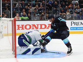 Canucks goalie Thatcher Demko makes the save against Nathan Bastian of the Seattle Kraken in the second period during the Kraken's inaugural home game on Oct. 23, 2021, at Climate Pledge Arena