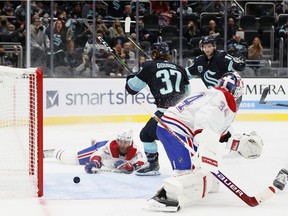 Kraken's Yanni Gourde beats Canadiens goalie Jake Allen as defenceman Brett Kulak can only watch from the ice during the second period in Seattle Tuesday night.