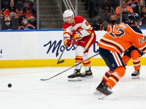 The Calgary Flames’ Walker Duehr shoots past the Edmonton Oilers’ Tyson Barrie during pre-season action at Rogers Place in Edmonton, on Monday, Oct. 4, 2021.