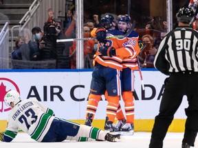 Edmonton Oilers' Zach Hyman (18) celebrates a goal with teammates on Vancouver Canucks' goaltender Thatcher Demko (35) at Rogers Place in Edmonton on Wednesday, Oct. 13, 2021.