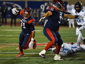 Alouettes running back William Stanback avoids a tackle by Argonauts' Jeff Richards in the second quarter during a Canadian Football League game at Molson Stadium.