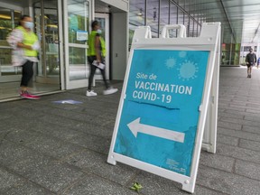 Women walk out of the COVID-19 vaccination clinic at the Palais des Congrès in Montreal Thursday August 19, 2021.