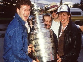 Edmonton Oilers Kevin Lowe, left, equipment manager Lyle 'Sparky' Kulchisky, Mark Messier and Wayne Gretzky hold the Stanley Cup after leaving David's Restaurant in Edmonton on May 21, 1984.