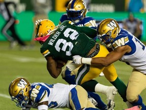 Edmonton Elks’ James Wilder Jr. is tackled by Winnipeg Blue Bombers’ Kyrie Wilson in Edmonton on Friday night. Ian Kucerak/Postmedia Network