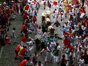 Runners sprint in front of Torrestrella fighting bulls at the entrance to the bullring during the first running of the bulls of the San Fermin festival in Pamplona July 7, 2014.