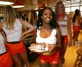 Hooters Girl Charmaine Fobbs (C) is followed by training coach Trisha Robinson (R) as the staff at the Hooters Restaurant gets ready for the opening of the world's first Hooters Casino Hotel in Las Vegas, Nevada.