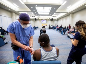 A health-care worker from Humber River hospital's mobile vaccination team administers the Moderna COVID-19 vaccine at The Church of Pentecost Canada in Toronto May 4, 2021.