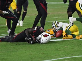 Jonathan Ward of the Arizona Cardinals and Kylin Hill of the Green Bay Packers are injured on a play during the second half of a game at State Farm Stadium on Oct. 28, 2021 in Glendale, Ariz.