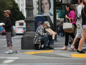 A homeless man holds a sign as he panhandles for spare change on September 16, 2010 in San Francisco, California.