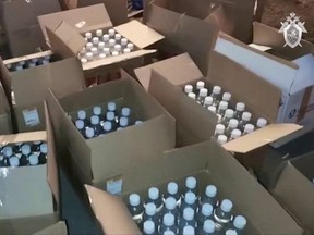 This video grab taken from a handout footage released by the Russian Investigative Committee on Oct. 8, 2021, shows bottles of surrogate alcohol that were uncovered at a warehouse in Orsk.