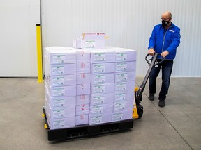 Michael Gray moves some of the first 500,000 AstraZeneca vaccine doses at a facility in Milton, Ont., March 3, 2021.
