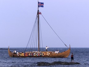 A tourist photographs the Viking replica ship the Islendingur as it arrives in the fishing village of L'Anse aux Meadows in Newfoundland, July 28, 2000.