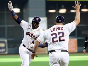 Astros' Yordan Alvarez celebrates with third base coach Omar Lopez while rounding the bases after hitting a solo home run during the 5th inning of Game 1 of the American League Division Series against the White Sox at Minute Maid Park in Houston, Thursday, Oct. 7, 2021.