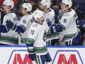 Vancouver Canucks forward Justin Dowling (73) is congratulated for his goal during the first period of the team's NHL hockey game against the Buffalo Sabres, Tuesday, Oct. 19, 2021, in Buffalo, N.Y.