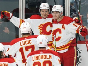 Calgary Flames forward Mikael Backlund (top left) celebrates what was believed to be a game-tying goal late during preseason NHL action against the Winnipeg Jets at Canada Life Centre in Winnipeg on Wednesday, Oct. 6, 2021. The goal was overturned after a replay showed Matthew Tkachuk (top right) played the puck with a high stick.