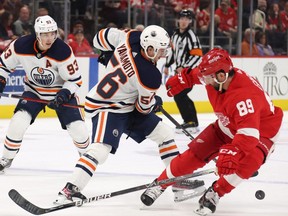 Kailer Yamamoto #56 of the Edmonton Oilers tries to get around Sam Gagner #89 of the Detroit Red Wings during the first period at Little Caesars Arena on November 09, 2021 in Detroit, Michigan.