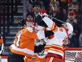 Justin Braun #61 of the Philadelphia Flyers and Elias Lindholm #28 of the Calgary Flames tangle in front of the Flyers net during the second period at Wells Fargo Center on Tuesday in Philadelphia.