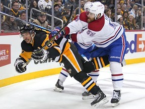 Penguins' Sidney Crosby (87) is checked to the ice by Canadiens' David Savard (58) in Pittsburgh on Saturday, Nov. 27, 2021.