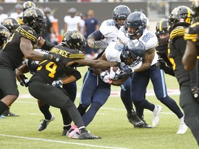 Toronto Argonauts Kurleigh Gittens Jr. looks for yardage against Hamilton Tiger Cats Desmond Lawrence (24) during first half CFL action in Hamilton, Ont. on Monday October 11, 2021.