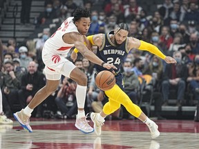 Raptors' Scottie Barnes (left) and Memphis Grizzlies' Dillon Brooks battle for the ball during the first quarter at Scotiabank Arena on Tuesday, Nov. 30, 2021.