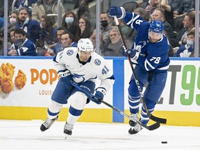 Maple Leafs' T.J. Brodie (right) and Tampa Bay Lightning's Pierre-Edouard Bellemare battle for the puck during the second period at Scotiabank Arena on Thursday, Nov. 4, 2021.