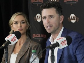 Buster Posey of the San Francisco Giants, along with his wife Kristen Posey, speaks at a press conference announcing his retirement from Major League Baseball at Oracle Park in San Francisco, Thursday, on Nov. 4, 2021.