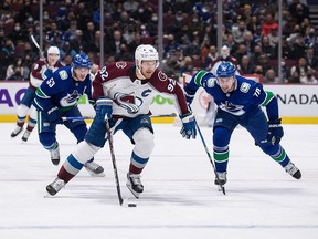 Colorado Avalanche's Gabriel Landeskog skates with the puck as Vancouver Canucks' Tanner Pearson gives chase in the first period.