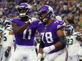 Laquon Treadwell (11) and Dakota Dozier (78) of the Vikings celebrate a touchdown during a preseason game at U.S. Bank Stadium in Minneapolis, Aug. 18, 2019.