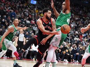 Raptors' Fred VanVleet passes the ball past Boston Celtics' Al Horford in the first half at Scotiabank Arena on Sunday, Nov. 28, 2021.