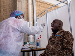 A healthcare worker conducts a PCR COVID-19 test at the Lancet laboratory in Johannesburg, South Africa, Tuesday, Nov. 30, 2021.