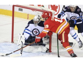 The Calgary Flames’ Matthew Tkachuk tries a wraparound shot against Winnipeg Jets goaltender Connor Hellebuyck at the Saddledome in Calgary on Saturday, Nov. 27, 2021.