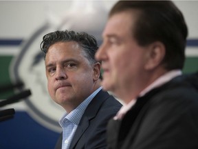 Head coach Travis Green, left, and general manager Jim Benning are at the forefront of focus as the Canucks' ownership ponders changes.