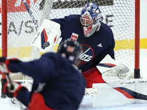 Goaltender Eric Comrie stops a shot from Mark Scheifele during Winnipeg Jets practice on Thurs., Nov. 4, 2021. KEVIN KING/Winnipeg Sun/Postmedia Network