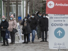 People line up for their COVID-19 vaccine at the St-Laurent vaccination centre on Ste-Croix Ave. on Monday December 27, 2021.