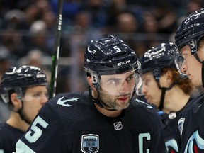 Kraken captain Mark Giordano talks with teammate Morgan Geekie during a game against the Winnipeg Jets at Climate Pledge Arena earlier this month in Seattle.