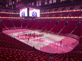 The Philadelphia Flyers and the Montreal Canadiens stand during the anthems in an empty Bell Centre in Montreal on Dec. 16, 2021 after the Quebec Government requested that the game be played without spectators.