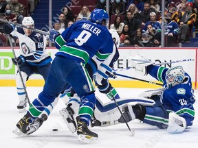 Canucks goalie Thatcher Demko makes the save as J.T. Miller checks Winnipeg Jets' Blake Wheeler during the first period at Rogers Arena in Vancouver on Friday, Dec. 10, 2021.