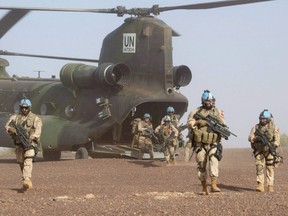 Canadian infantry and medical personnel disembark a Chinook helicopter as they take part in a medical evacuation demonstration on the United Nations base in Gao, Mali, Dec. 22, 2018.
