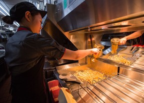 McDonald's Japan Swing Manager Miwa Suzuki sprinkles salt on french fries on January 25, 2016 in Tokyo, Japan. (Photo by Christopher Jue/Getty Images)